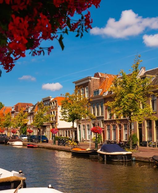 Colourful canal houses and moored boats on a sunny Leiden canal, the Netherlands