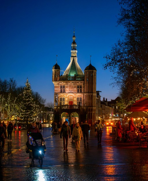 Festive Christmas scene in Deventer, Netherlands, with historic buildings lit by warm lights